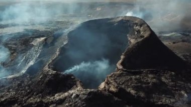 Fagradalsjall 'ın 4K hava aracı görüntüleri Geldingadalir, Reykjanes, İzlanda' da hafif aktif bir volkan patlaması. Duman ve dramatik gökyüzü ile çevrili soğuk lav. İzlanda Volkanik Patlaması Grindavik.