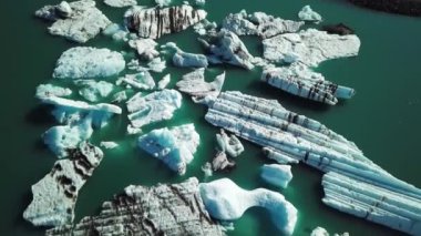 Aerial drone footage of icebergs floating in Jokulsarlon glacier lagoon in Iceland. Scenic view of Ice bergs. Artic nature ice landscape. Melting glacier in Iceland. Global warming, climate change.