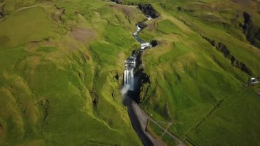 İzlanda 'nın güneyindeki Skogafoss Şelalesi' nin yukarısından 4K hava aracı görüntüleri. Skogafoss, İzlanda 'nın ünlü şelalesi. Skogafoss 'un manzarası, muhteşem doğal mucize..