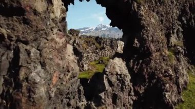Kayanın camından uçarak. Arkadaki Snaefellsjokull buzulu kayadaki bir delikten görülebiliyor. Yüksek kalite 4K görüntü. İzlanda 'da dağlar ve buzullar. 