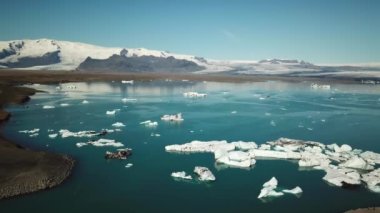 Aerial drone footage of icebergs floating in Jokulsarlon glacier lagoon in Iceland. Scenic view of Ice bergs. Artic nature ice landscape. Melting glacier in Iceland. Global warming, climate change.