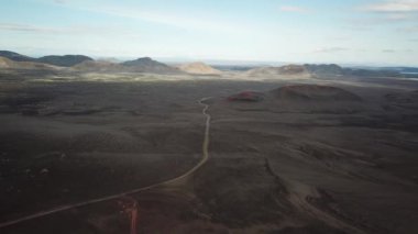 4K hava aracı Landmannalaugar 'ın etrafındaki çarpıcı dağların olduğu asfaltsız bir yol ve manzaranın görüntüleri. İzlanda 'da gökkuşağı dağları.