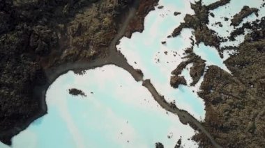 İzlanda 'daki Blue Lagoon Spa' nın 4K hava aracı görüntüleri. Jeotermal kaplıca. Mavi sular siyah toprakla çelişiyor. Açık doğal havuz üzerinde uçmak. Yüksek kalite 4k görüntü