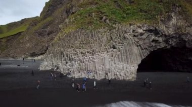 İzlanda 'daki Vik yakınlarında Reynisfjara Sahili' nde bazalt sütunlu bir havadan insansız hava aracı görüntüsü. Siyah kum plajı. Yüksek kalite 4k görüntü