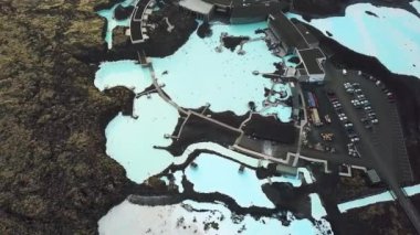 İzlanda 'daki Blue Lagoon Spa' nın 4K hava aracı görüntüleri. Jeotermal kaplıca. Mavi sular siyah toprakla çelişiyor. Açık doğal havuz üzerinde uçmak. Yüksek kalite 4k görüntü