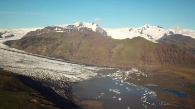 Aerial drone footage of Vatnajokull ice tongue. Skaftafell glacier with icebergs floating in a glacier lagoon. Scenic view of Vatnajokull. Artic nature ice landscape. Melting glacier in Iceland.