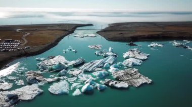 Aerial drone footage of icebergs floating in Jokulsarlon glacier lagoon in Iceland. Scenic view of Ice bergs. Artic nature ice landscape. Melting glacier in Iceland. Global warming, climate change.