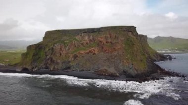 İzlanda, Vik yakınlarındaki Reynisfjara Sahili 'ndeki bir masa dağının insansız hava aracı görüntüleri. Siyah kum plajı. Yüksek kalite 4k görüntü