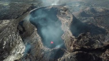 Fagradalsjall 'ın 4K hava aracı görüntüleri Geldingadalir, Reykjanes, İzlanda' da hafif aktif bir volkan patlaması. Duman ve dramatik gökyüzü ile çevrili soğuk lav. İzlanda Volkanik Patlaması Grindavik.
