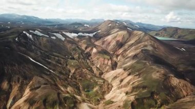 Landmannalaugar 'ın etrafındaki muhteşem dağların olduğu bir İzlanda manzarasının 4K sinematik hava aracı görüntüleri. İzlanda 'da gökkuşağı dağları. Blahnjukur ve Laugahraun. Yosun kaplı lav alanları, İzlanda