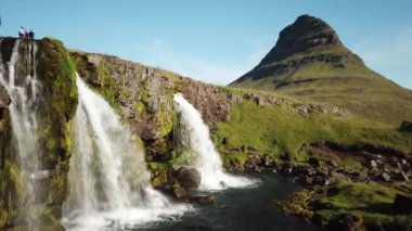 Aerial Drone footage of Kirkjufell mountain and waterfall in the snaefellsnes peninsula, during summer. High quality 4k footage