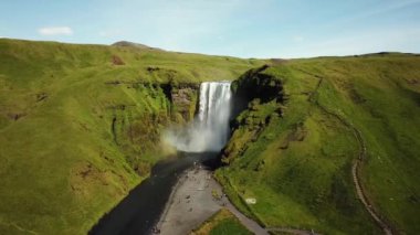 İzlanda 'nın güneyinde gökkuşağı olan Skogafoss Şelalesi' nin 4K hava aracı görüntüleri. Skogafoss, İzlanda 'nın ünlü şelalesi. Skogafoss 'un manzarası, muhteşem doğal mucize..