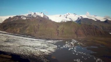 Aerial drone footage of Vatnajokull ice tongue. Skaftafell glacier with icebergs floating in a glacier lagoon. Scenic view of Vatnajokull. Artic nature ice landscape. Melting glacier in Iceland.