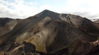 Landmannalaugar 'ın etrafındaki muhteşem dağların olduğu İzlanda hava aracı görüntüleri. İzlanda 'da gökkuşağı dağları. Yosun İzlanda 'daki lav tarlalarını kapladı. Yüksek kalite 4k görüntü