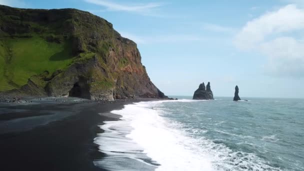 在冰岛维克附近的里尼斯法哈拉海滩 空中无人侦察机拍摄到的火山岩从海里伸出的镜头 黑色沙滩上的尖尖岩石悬崖 含玄武岩柱的玄武岩洞 高质量的4K镜头 — 图库视频影像