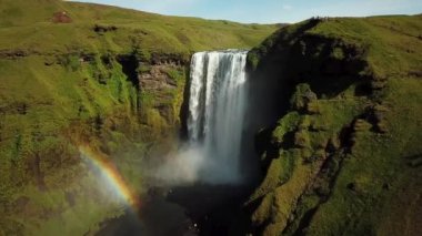 İzlanda 'nın güneyinde gökkuşağı olan Skogafoss Şelalesi' nin 4K hava aracı görüntüleri. Skogafoss, İzlanda 'nın ünlü şelalesi. Skogafoss 'un manzarası, muhteşem doğal mucize..