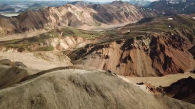 Landmannalaugar 'ın etrafındaki muhteşem dağların olduğu bir İzlanda manzarasının 4K sinematik hava aracı görüntüleri. İzlanda 'da gökkuşağı dağları. Blahnjukur ve Laugahraun. Yosun kaplı lav alanları, İzlanda