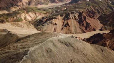 Landmannalaugar 'ın etrafındaki muhteşem dağların olduğu bir İzlanda manzarasının 4K sinematik hava aracı görüntüleri. İzlanda 'da gökkuşağı dağları. Blahnjukur ve Laugahraun. Yosun kaplı lav alanları, İzlanda