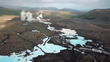 İzlanda 'daki Blue Lagoon Spa' nın 4K hava aracı görüntüleri. Jeotermal kaplıca. Mavi sular siyah toprakla çelişiyor. Açık doğal havuz üzerinde uçmak. Yüksek kalite 4k görüntü