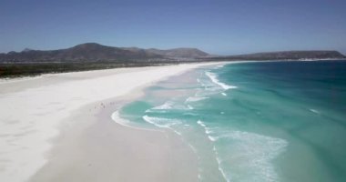 Noordhoek Long Beach 'in 4K hava aracı görüntüleri, Cape Town, Güney Afrika. Okyanus dalgalarının geniş görüşü. Turkuaz temiz su ve beyaz kumsal. Yüksek kalite 4k görüntü