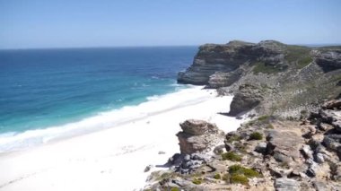 Güney Afrika, Cape Town 'daki Diaz Sahili' nin 4K görüntüleri. Rocky Cliffs ve Turkuaz temiz su Cape Peninsula 'da beyaz kumlu plaj. Cape Point Doğa Koruma Alanı. Özel bir fauna ve bitki örtüsü var.