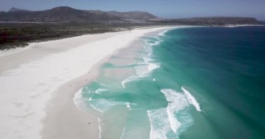 Noordhoek Long Beach 'in 4K hava aracı görüntüleri, Cape Town, Güney Afrika. Okyanus dalgalarının geniş görüşü. Turkuaz temiz su ve beyaz kumsal. Yüksek kalite 4k görüntü