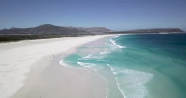 Noordhoek Long Beach 'in 4K hava aracı görüntüleri, Cape Town, Güney Afrika. Okyanus dalgalarının geniş görüşü. Turkuaz temiz su ve beyaz kumsal. Yüksek kalite 4k görüntü