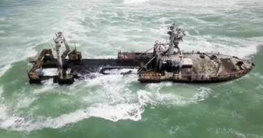 Namibya 'nın ünlü iskelet sahilinde terk edilmiş bir gemi enkazı Zeila' nın 4K hava aracı görüntüsü. Namibya Atlantik kıyı şeridi, Zeila L-758 Walvis Körfezi İskelet Sahil Parkı 'ndaki kumsalda paslı bir gemi mahsur kaldı.