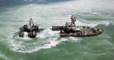 Namibya 'nın ünlü iskelet sahilinde terk edilmiş bir gemi enkazı Zeila' nın 4K hava aracı görüntüsü. Namibya Atlantik kıyı şeridi, Zeila L-758 Walvis Körfezi İskelet Sahil Parkı 'ndaki kumsalda paslı bir gemi mahsur kaldı.