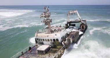 Namibya 'nın ünlü iskelet sahilinde terk edilmiş bir gemi enkazı Zeila' nın 4K hava aracı görüntüsü. Namibya Atlantik kıyı şeridi, Zeila L-758 Walvis Körfezi İskelet Sahil Parkı 'ndaki kumsalda paslı bir gemi mahsur kaldı.