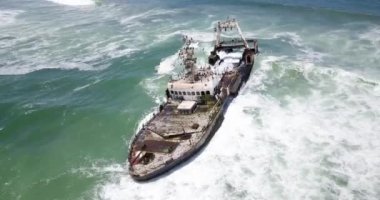 Namibya 'nın ünlü iskelet sahilinde terk edilmiş bir gemi enkazı Zeila' nın 4K hava aracı görüntüsü. Namibya Atlantik kıyı şeridi, Zeila L-758 Walvis Körfezi İskelet Sahil Parkı 'ndaki kumsalda paslı bir gemi mahsur kaldı.