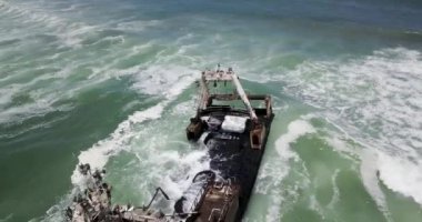 Namibya 'nın ünlü iskelet sahilinde terk edilmiş bir gemi enkazı Zeila' nın 4K hava aracı görüntüsü. Namibya Atlantik kıyı şeridi, Zeila L-758 Walvis Körfezi İskelet Sahil Parkı 'ndaki kumsalda paslı bir gemi mahsur kaldı.
