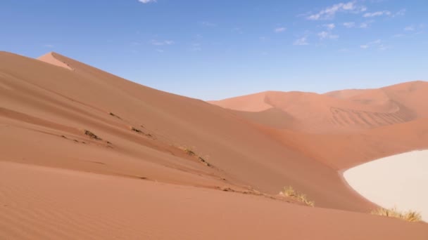 ソススススヴレイの赤い砂漠の砂丘やナミビアのセサリームと乾燥した粘土鍋 ナミブ デザートとビッグ デューン 小さな雲と青空オレンジ砂漠 4Kシネマティック映像 — ストック動画