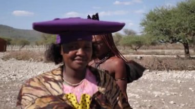 Opuwo, Namibya - 24 Temmuz 23: Himba kabilesinden kadın ve Herero kabilesinden kadın yan yana duruyordu. Namibya, Afrika 'da yaşayan yerli kabile. Yüksek kalite 4k görüntü