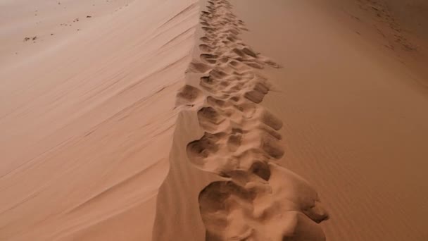 在炽热的橙色纳米布沙漠的脚印 Sossusvlei或纳米比亚Sesriem的红色沙漠沙丘 Deadvlei的大爸爸沙丘橙色沙丘 4K电影镜头 — 图库视频影像