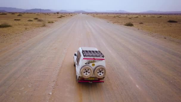 ナミビアの砂漠ナミブを横断する4X4サファリカーのドローン映像 4Kシネマティック映像 — ストック動画