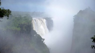 Zambiya sınırındaki Zimbabwe 'deki Victoria Şelalesi' nin yavaş çekim görüntüleri. Dünyanın Yeni 7 Doğal Harikası. Zambezi nehrinde Mosi-oa-Tunya.