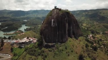 Kolombiya, Medellin yakınlarındaki El Penon de Guatape 'in insansız hava aracı görüntüleri. Büyük ve benzersiz bir kaya. Tepeye çıkan merdivenleri var. Turistik bir yer. Kolombiya 'da büyük bir taş. Yüksek kalite 4k görüntü.