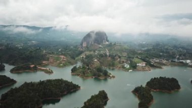 Kolombiya, Medellin yakınlarındaki El Penon de Guatape 'in insansız hava aracı görüntüleri. Büyük ve benzersiz bir kaya. Tepeye çıkan merdivenleri var. Turistik bir yer. Kolombiya 'da büyük bir taş. Yüksek kalite 4k görüntü.