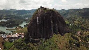 Kolombiya, Medellin yakınlarındaki El Penon de Guatape 'in insansız hava aracı görüntüleri. Büyük ve benzersiz bir kaya. Tepeye çıkan merdivenleri var. Turistik bir yer. Kolombiya 'da büyük bir taş. Yüksek kalite 4k görüntü.