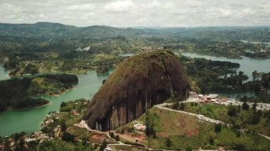 Kolombiya, Medellin yakınlarındaki El Penon de Guatape 'in insansız hava aracı görüntüleri. Büyük ve benzersiz bir kaya. Tepeye çıkan merdivenleri var. Turistik bir yer. Kolombiya 'da büyük bir taş. Yüksek kalite 4k görüntü.
