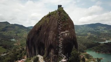 Kolombiya, Medellin yakınlarındaki El Penon de Guatape 'in insansız hava aracı görüntüleri. Büyük ve benzersiz bir kaya. Tepeye çıkan merdivenleri var. Turistik bir yer. Kolombiya 'da büyük bir taş. Yüksek kalite 4k görüntü.