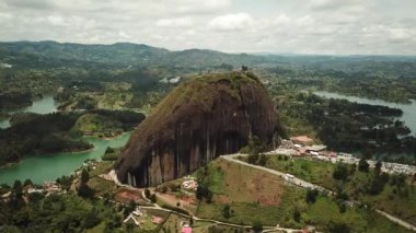 Kolombiya, Medellin yakınlarındaki El Penon de Guatape 'in insansız hava aracı görüntüleri. Büyük ve benzersiz bir kaya. Tepeye çıkan merdivenleri var. Turistik bir yer. Kolombiya 'da büyük bir taş. Yüksek kalite 4k görüntü.