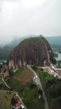 Kolombiya, Medellin yakınlarındaki El Penon de Guatape 'in insansız hava aracı görüntüleri. Büyük ve benzersiz bir kaya. Tepeye çıkan merdivenleri var. Turistik bir yer. Kolombiya 'da büyük bir taş. Yüksek kalite 4k görüntü.