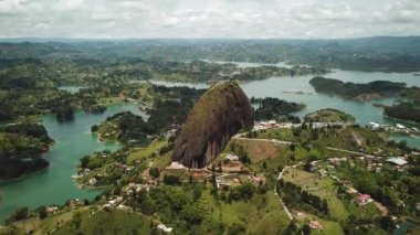 Kolombiya, Medellin yakınlarındaki El Penon de Guatape 'in insansız hava aracı görüntüleri. Büyük ve benzersiz bir kaya. Tepeye çıkan merdivenleri var. Turistik bir yer. Kolombiya 'da büyük bir taş. Yüksek kalite 4k görüntü.