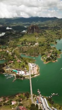 Kolombiya, Medellin yakınlarındaki El Penon de Guatape 'in insansız hava aracı görüntüleri. Büyük ve benzersiz bir kaya. Tepeye çıkan merdivenleri var. Turistik bir yer. Kolombiya 'da büyük bir taş. Yüksek kalite 4k görüntü.