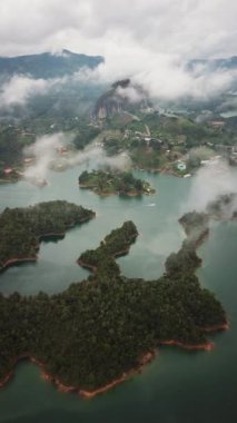 Kolombiya, Medellin yakınlarındaki El Penon de Guatape 'in insansız hava aracı görüntüleri. Büyük ve benzersiz bir kaya. Tepeye çıkan merdivenleri var. Turistik bir yer. Kolombiya 'da büyük bir taş. Yüksek kalite 4k görüntü.