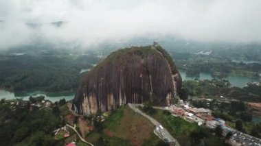 Kolombiya, Medellin yakınlarındaki El Penon de Guatape 'in insansız hava aracı görüntüleri. Büyük ve benzersiz bir kaya. Tepeye çıkan merdivenleri var. Turistik bir yer. Kolombiya 'da büyük bir taş. Yüksek kalite 4k görüntü.
