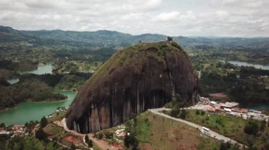 Kolombiya, Medellin yakınlarındaki El Penon de Guatape 'in insansız hava aracı görüntüleri. Büyük ve benzersiz bir kaya. Tepeye çıkan merdivenleri var. Turistik bir yer. Kolombiya 'da büyük bir taş. Yüksek kalite 4k görüntü.
