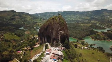 Kolombiya, Medellin yakınlarındaki El Penon de Guatape 'in insansız hava aracı görüntüleri. Büyük ve benzersiz bir kaya. Tepeye çıkan merdivenleri var. Turistik bir yer. Kolombiya 'da büyük bir taş. Yüksek kalite 4k görüntü.